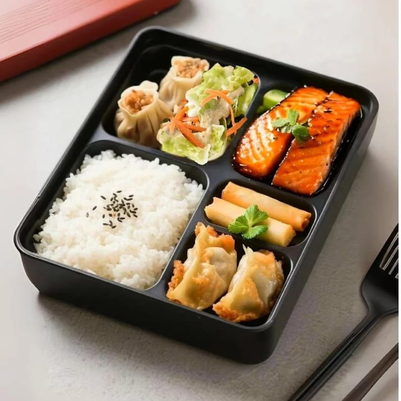 Linsway Grill & Teriyaki bento box with salmon, rice, dumplings, spring rolls, and salad.