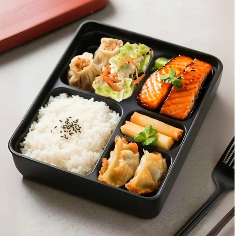 Linsway Grill & Teriyaki bento box with salmon, rice, dumplings, spring rolls, and salad.